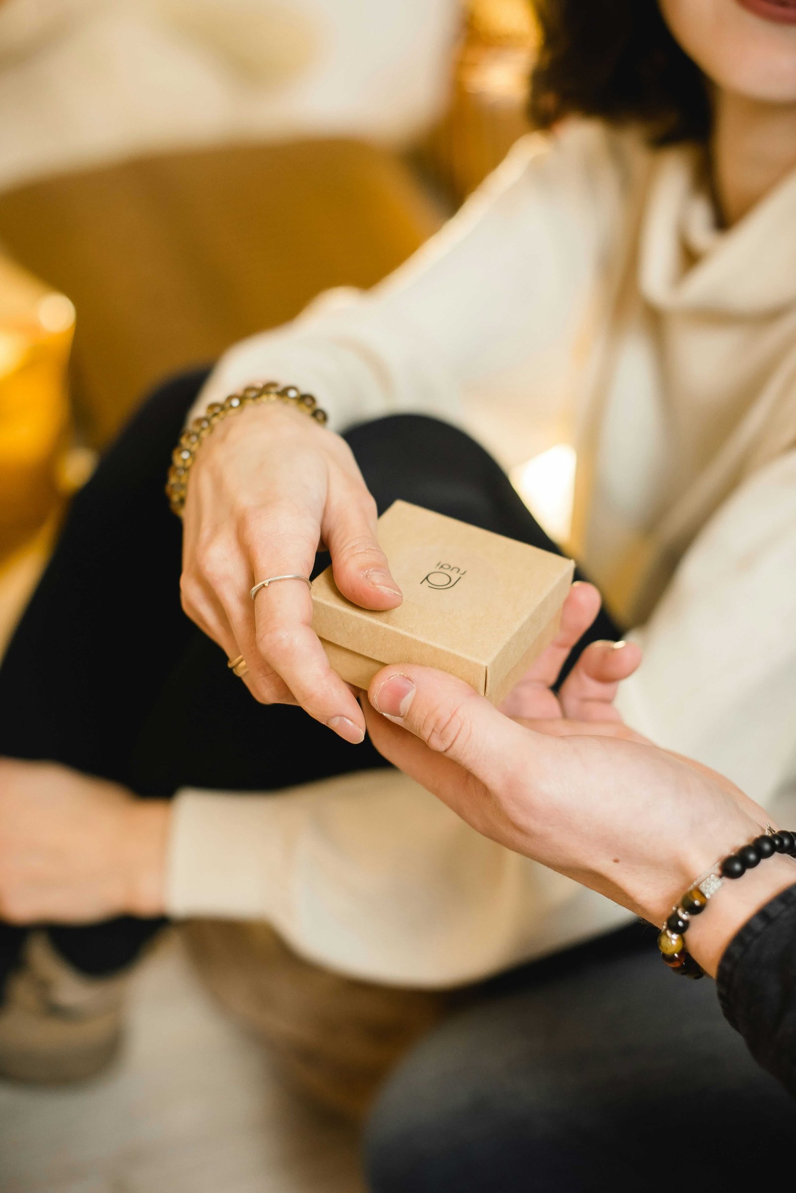 Hands tying a ribbon around a carefully wrapped gift