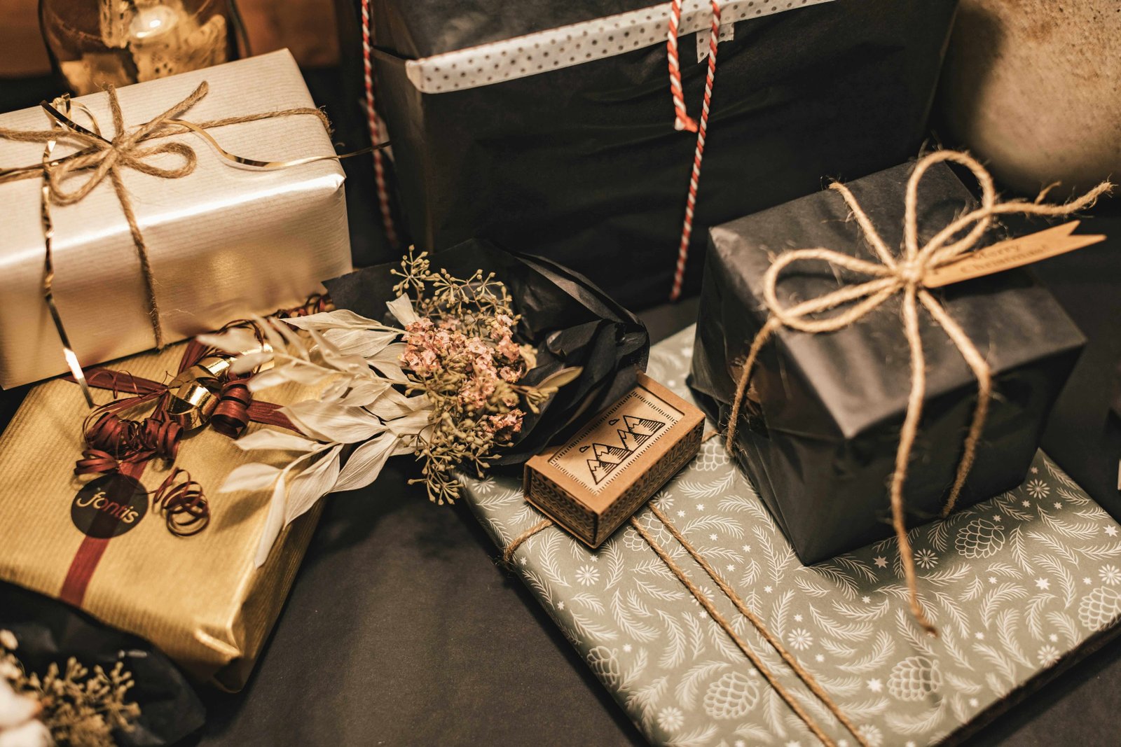 Gold and silver gift boxes arranged with ribbons and dried flowers